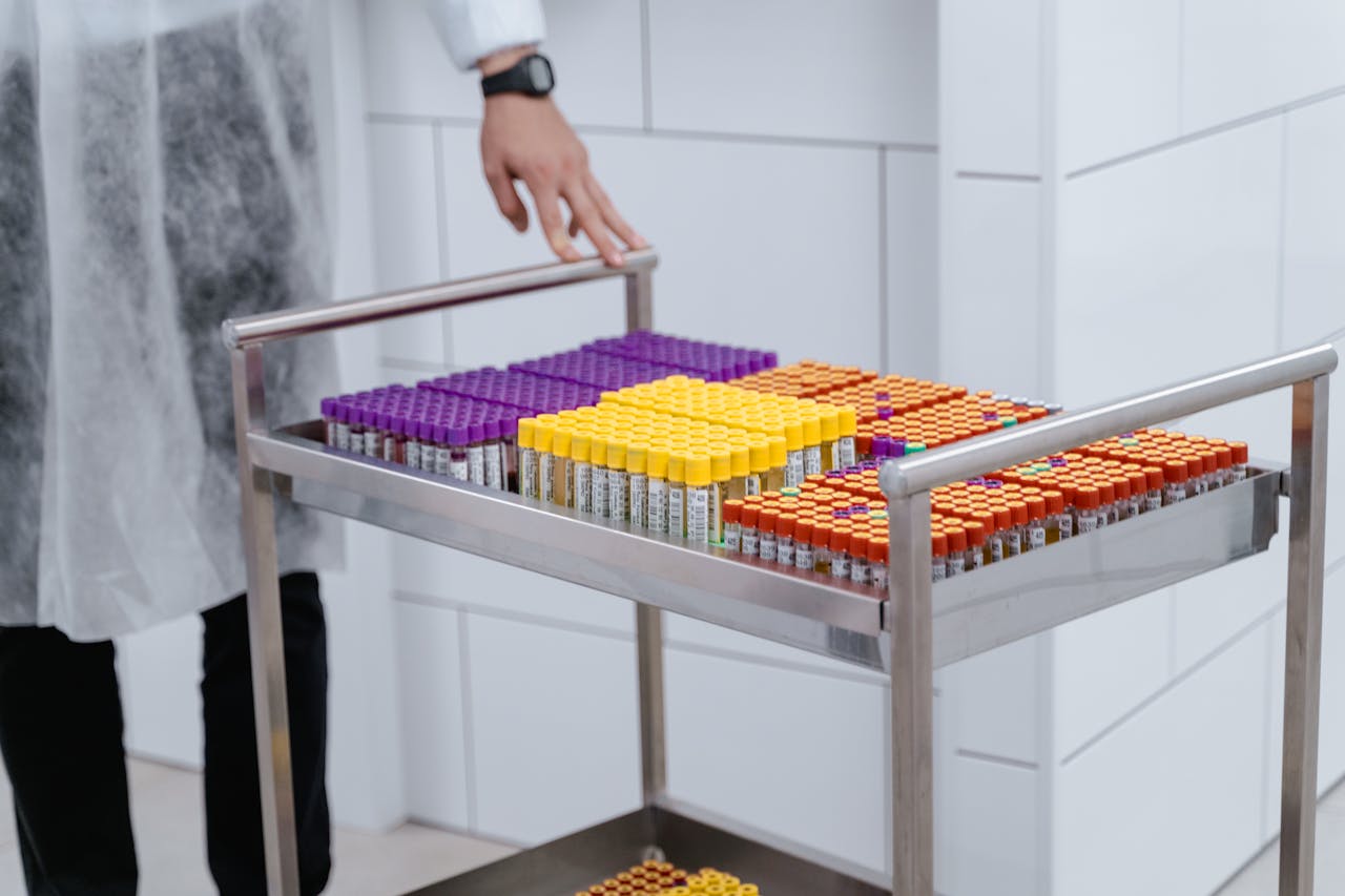 Organized laboratory test samples in colorful capped vials on a steel cart.