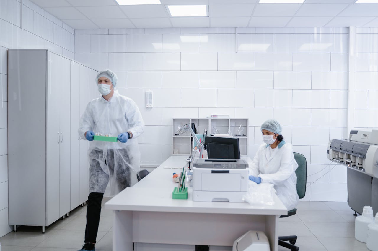 Researchers conducting experiments in a clean, modern laboratory environment wearing protective gear.